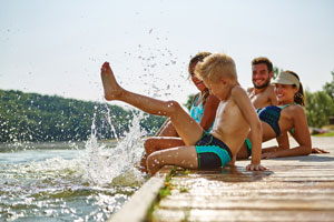 Photo of family sitting on dock at lake, CA